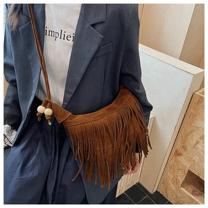 Detail of bohemian dark brown suede tassel shoulder bag with wooden bead accents