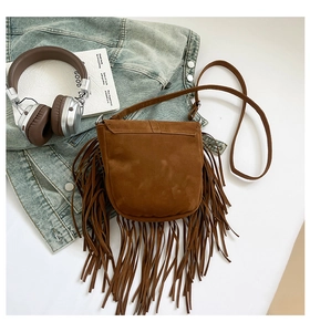 Détail du sac de selle en daim marron avec de longues franges et une fine bandoulière