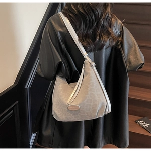 Gray leopard print hobo bag with adjustable strap and metal buckle shown on a model