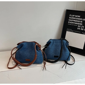 Dual denim bucket bags with woven handles displayed on a white marble surface
