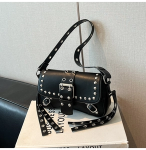 Detail of black punk shoulder bag featuring silver rivets and metal buckle strap