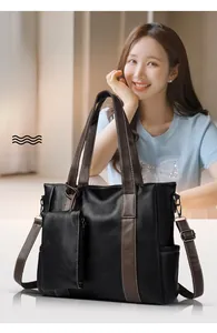 Detail view of contrast strap leather tote with detachable pouch on female model