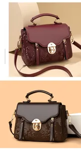Detail view of wine red and dark brown crossbody bags with snakeskin texture and tassels