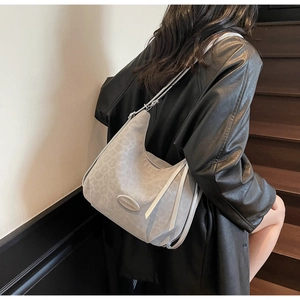 Detail of grey leopard print hobo bag showing the texture and metal decorative element