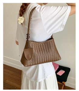 Detailed view of woven brown leather shoulder bag with matching mini round pouch accessory