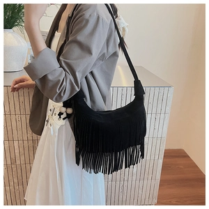 Close-up of black suede fringe shoulder bag featuring bohemian wooden bead tassels