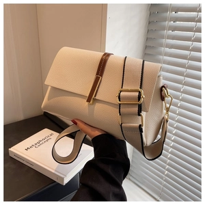 Close-up of off-white lychee leather crossbody bag with wide strap and gold buckle