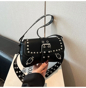 Detail shot of black leather baguette bag with silver studs and large metal buckle