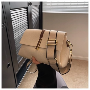 Beige lychee leather crossbody bag with wide woven strap and gold hardware detail
