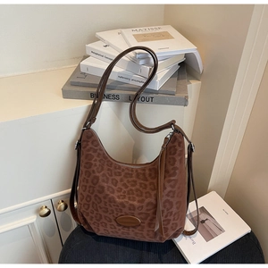 Detail of leopard print hobo bag in brown suede texture with stylish fringe tassel decor