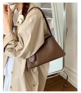 Close-up of deep brown woven leather texture on a spacious tote bag with shoulder strap
