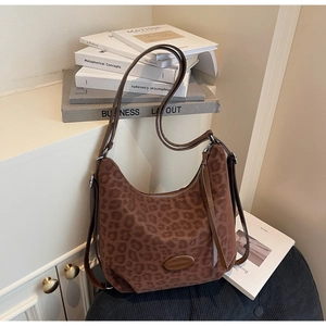 Detail of hobo bag featuring leopard print texture and metal zipper closure