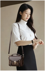 Detail of retro dark brown crossbody bag with snake-embossed flap and gold metal clasp