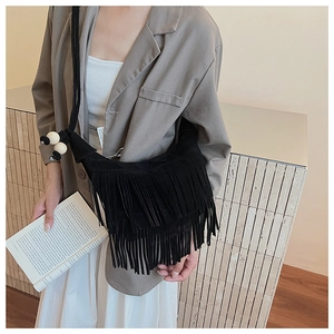 Detail of vintage black suede underarm bag with long tassels and wooden bead strap