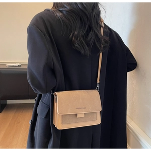 Detail of khaki square crossbody bag with mixed textures and fashion lettering on flap
