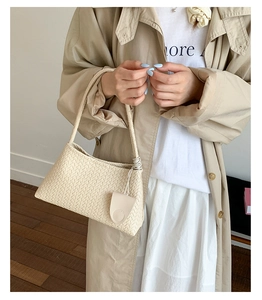 Detail of classic woven texture on beige hobo bag with a matching small hanging pouch