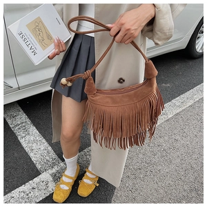 Detail of caramel brown suede fringe bag with wooden beads and bohemian crescent shape