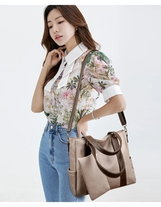 Close-up of khaki tote bag with dark brown contrast handles and a small purse attachment