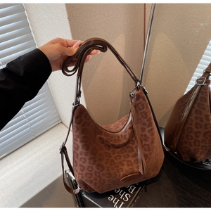 Detail of leopard print hobo bag showing faux suede texture and adjustable strap