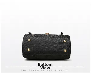 Close-up of the black snake skin texture on bag bottom with four golden metal feet