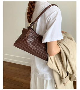 Detail view of deep brown woven shoulder bag with unique knotted strap on model