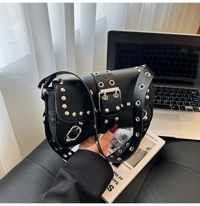 Close-up of black punk shoulder bag with silver rivets and studs in a lifestyle setting