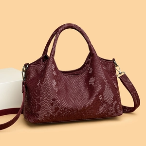 Burgundy faux snakeskin tote bag with double handles and silver hardware in soft light