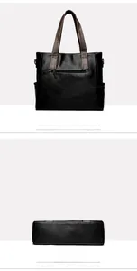 Detail view of the black leather tote bag back with brown straps and functional zip pocket