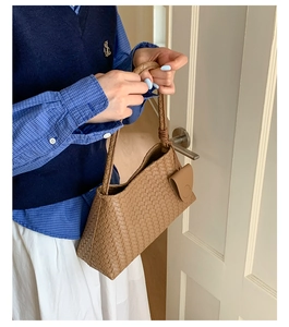 Detail of classic brown woven leather texture and elegant handle on the large tote bag