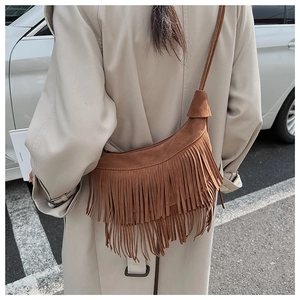 Detailed back view of a brown suede crescent bag with bohemian fringe and shoulder strap