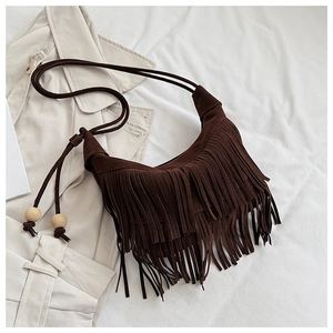 Detail of dark brown suede shoulder bag with long fringes and decorative wood beads