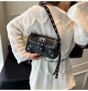 Detailed view of black motorcycle-style underarm bag with silver rivets and buckles