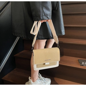 Dettaglio della borsa a tracolla crema minimalista con patta kaki e ampia tracolla moda