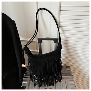 Detail view of black faux suede fringe shoulder bag with wooden bead tassels and drawstring
