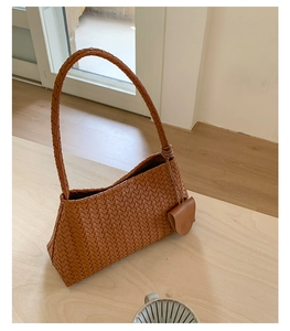 Detailed close-up of brown woven hobo bag with matching small coin purse accessory