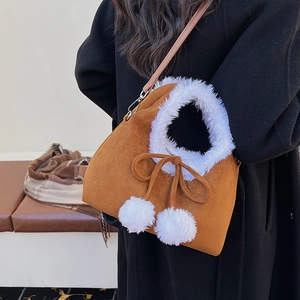 Retro brown suede bucket bag with white plush trim and fuzzy pom-poms on black coat
