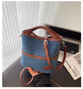 Detail der Eimer-Tasche aus Denim und braunem Leder mit Metallschnalle und Trageriemen