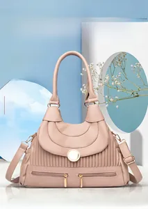Détail du sac à bandoulière rose poudré avec plis, fermoir doré et poches zippées
