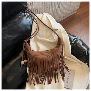 Close-up of brown suede hobo bag with tiered fringe tassels and decorative wooden beads