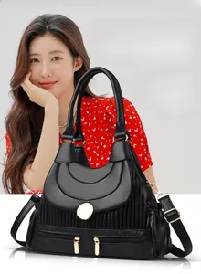 Vue détaillée du sac en cuir de vache noir avec texture plissée et boucle dorée ronde