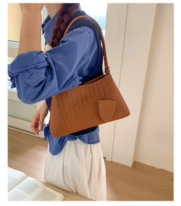 Detail of caramel woven leather shoulder bag with fine texture and stylish tag