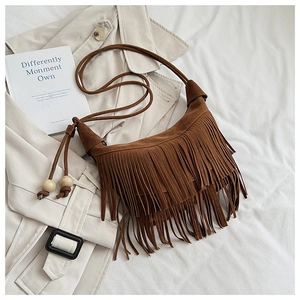 Detail of vintage suede shoulder bag with dense double-layered fringes and wood bead accents