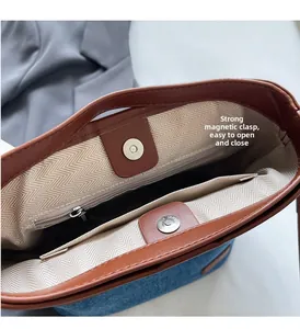 Detail view of denim bucket bag interior with magnetic snap closure and leather trim