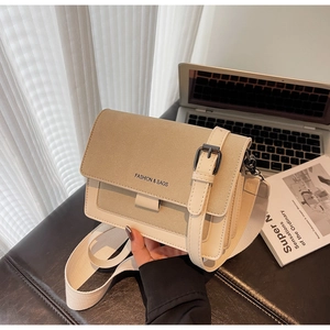 Dettaglio borsa a tracolla bicolore beige con ampia cinghia e chiusura a patta