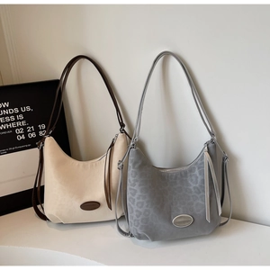 Detail view of crescent shoulder bags in matte beige and grey leopard print textures