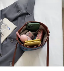 Top-down view of a spacious denim bucket bag interior with phone, wallet, and umbrella