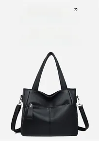 Detail of black pebbled leather tote bag with vertical stitching and round handles
