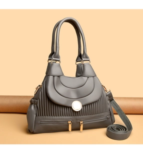 Détail du sac à main plissé gris foncé avec boucle magnétique dorée et fermoirs zippés