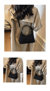 Detail view of a black hobo shoulder bag featuring tonal studs and a chic crescent shape