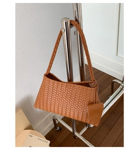 Detailed close-up of woven caramel leather texture and matching triangle coin purse